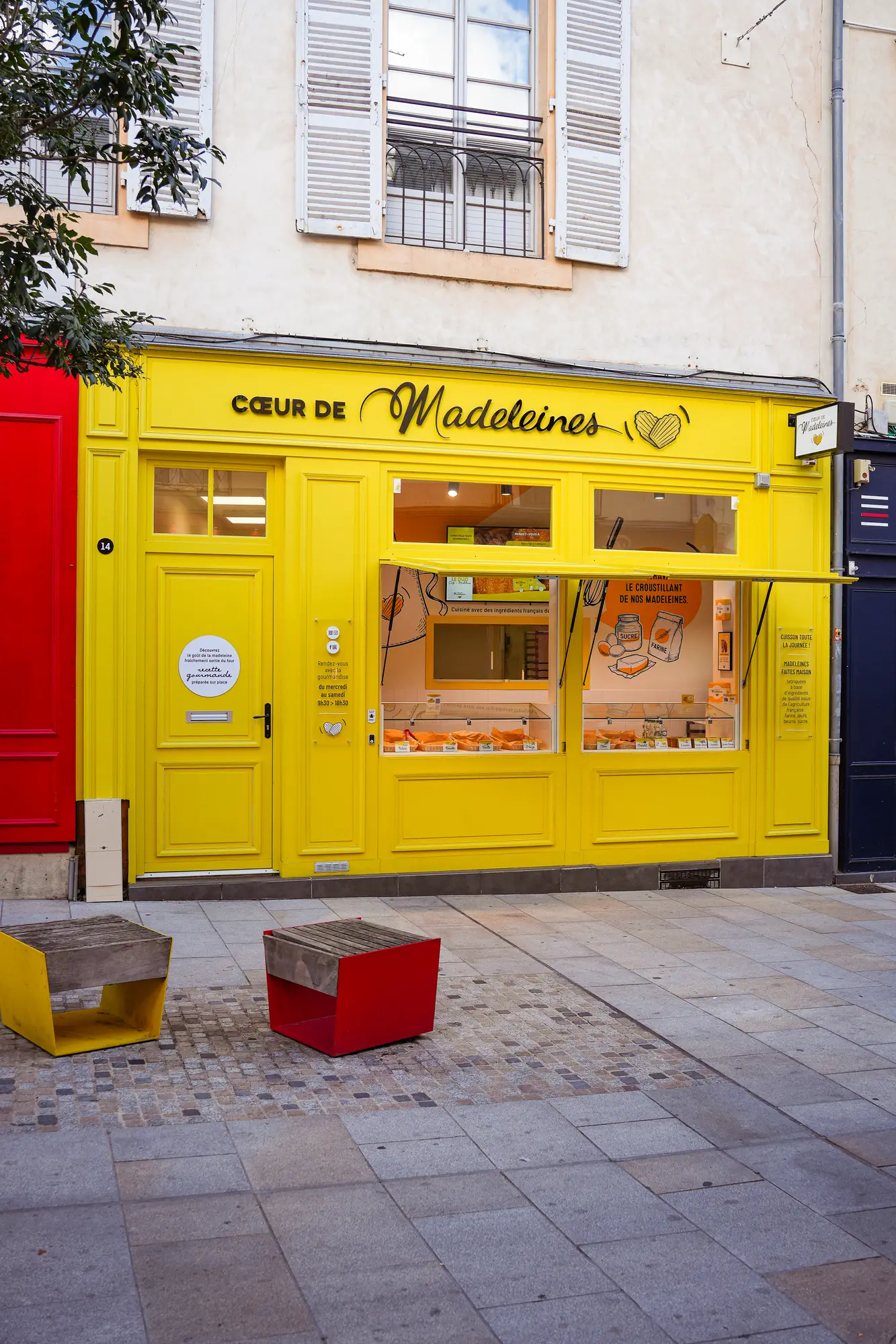 Boutique de madeleines à la façade jaune, vue de la rue