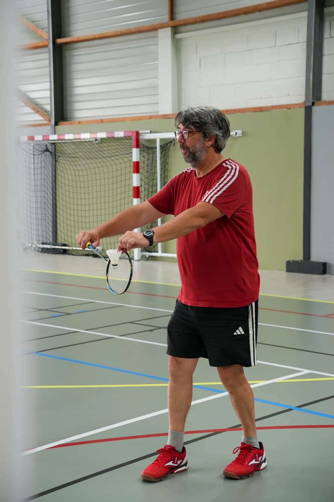 Joueur de badminton au service pendant un tournoi