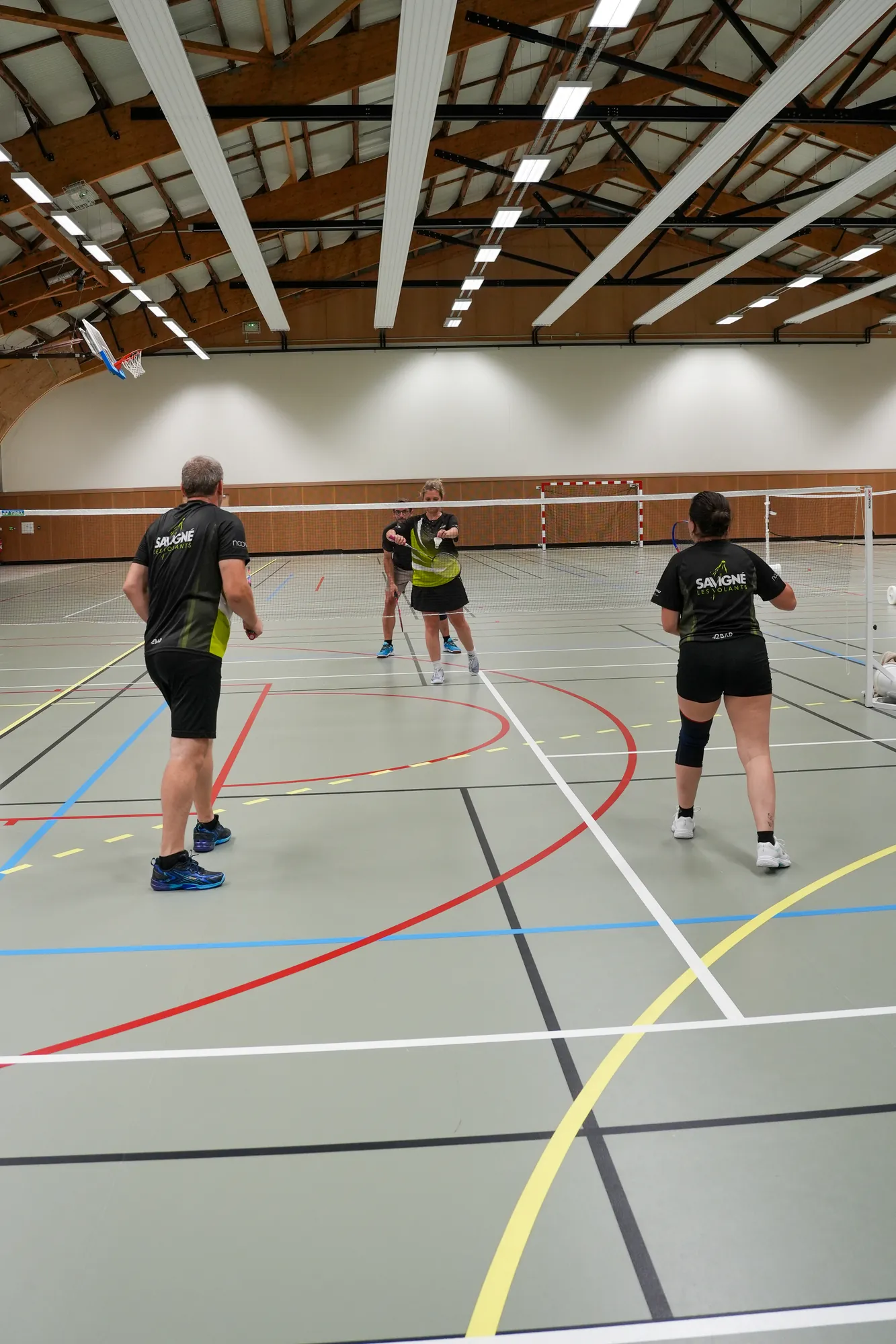 Match de double dans un gymnase pendant un tournoi de badminton