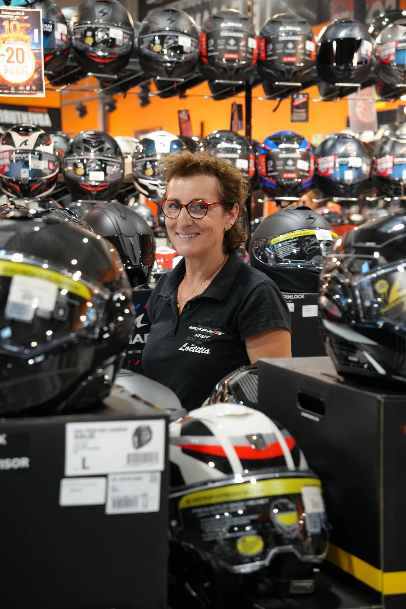 Vendeuse au rayon casques d'une concession moto
