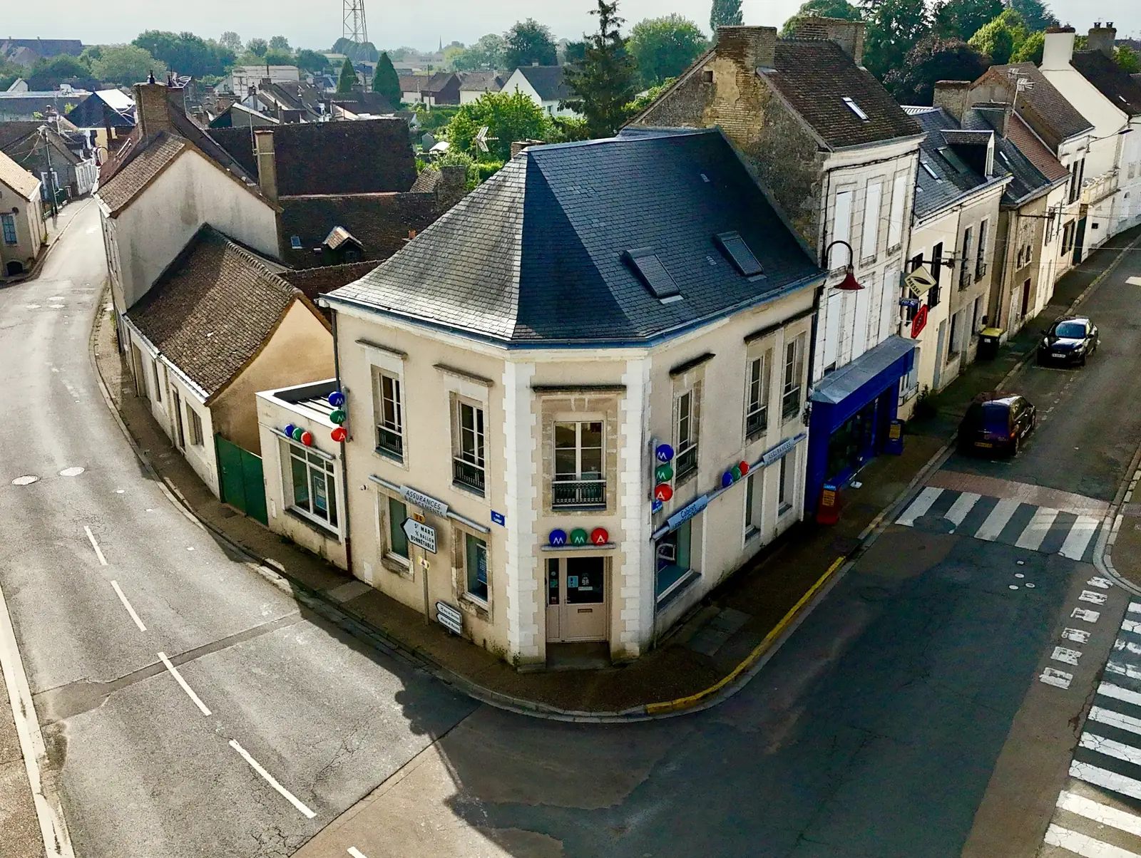 Maison de ville à l'angle d'une rue filmée au drone pour une agence immobilière