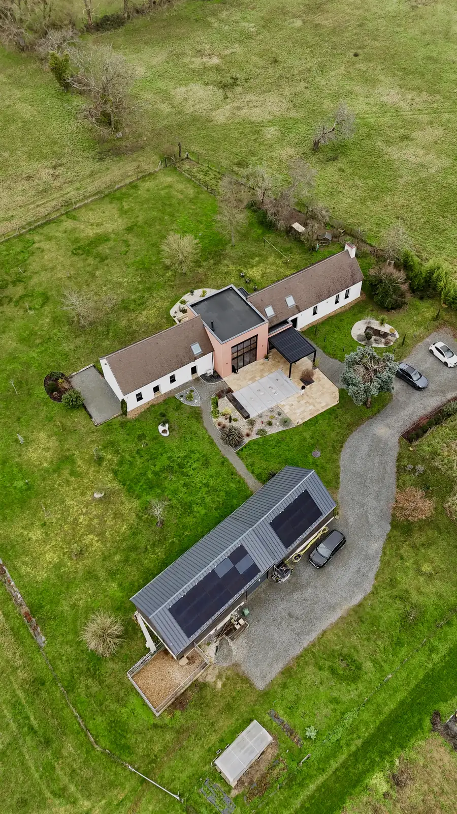 Maison avec panneaux solaires vue du ciel pour l'annonce d'un mandataire